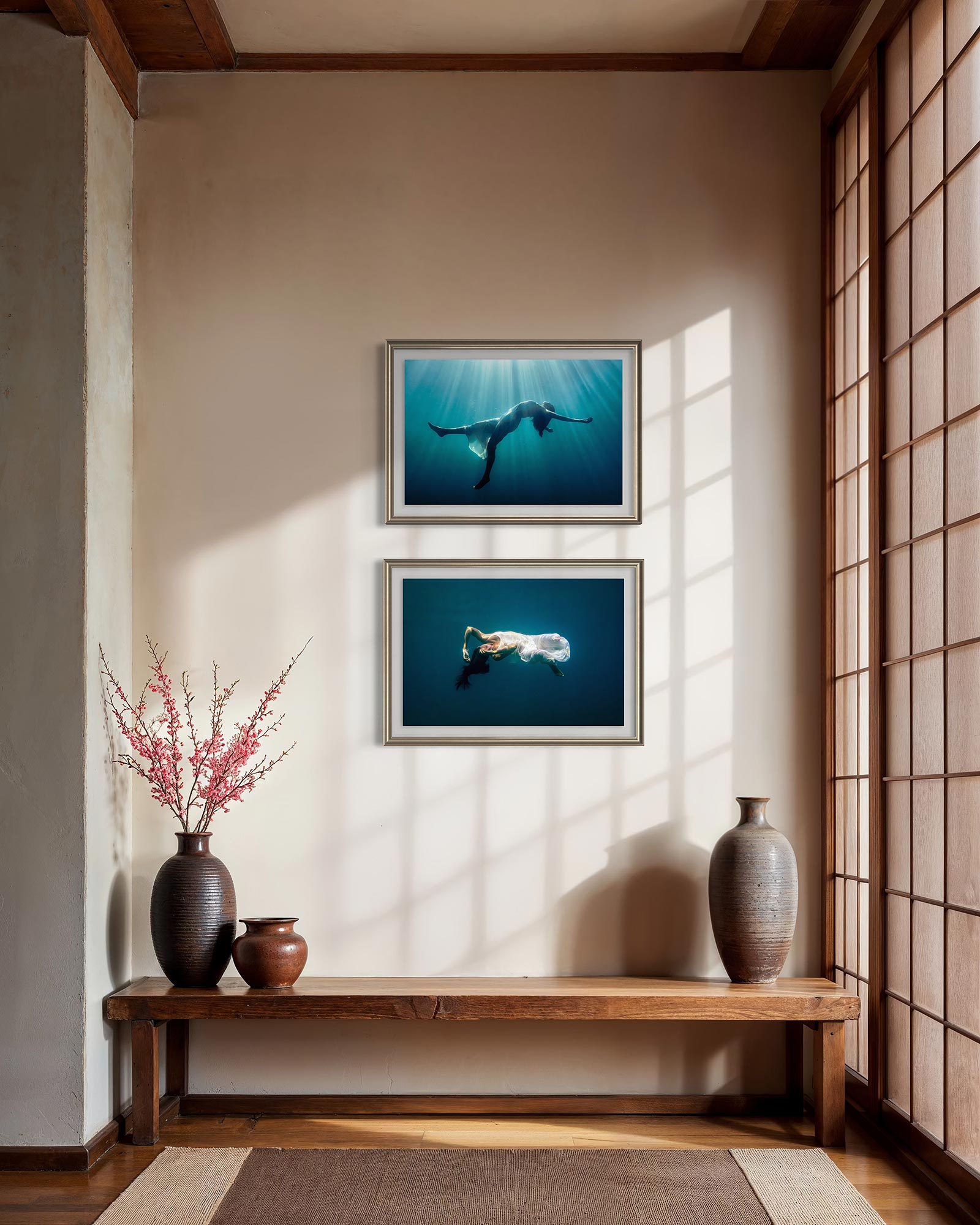 Two underwater fine art photographs styled as wall art one above another in a simple modern kitchen interior.