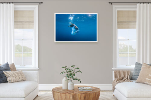 A mockup showing a Fine art photo of a woman in water, hanged and framed on a wall.